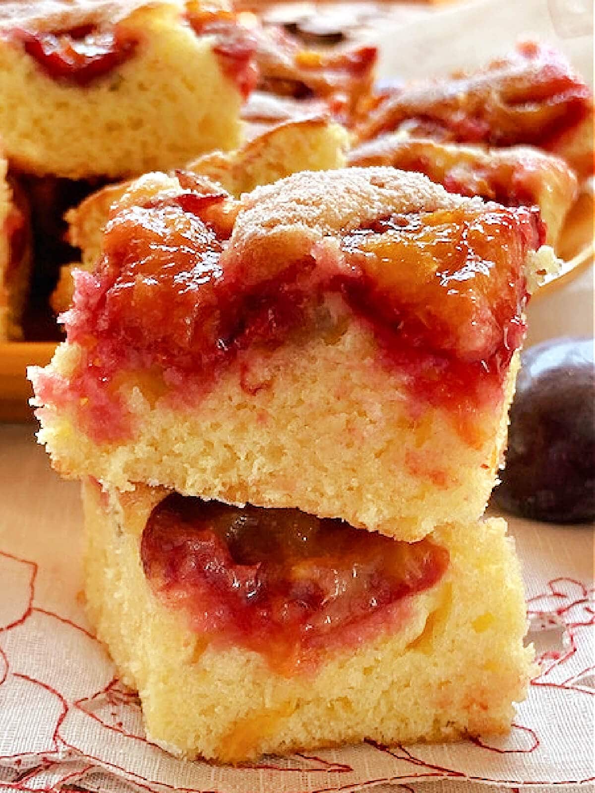 A stack of 2 slices of plum cake.