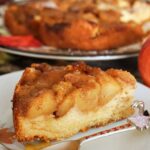 A slice of apple cake on a white plate