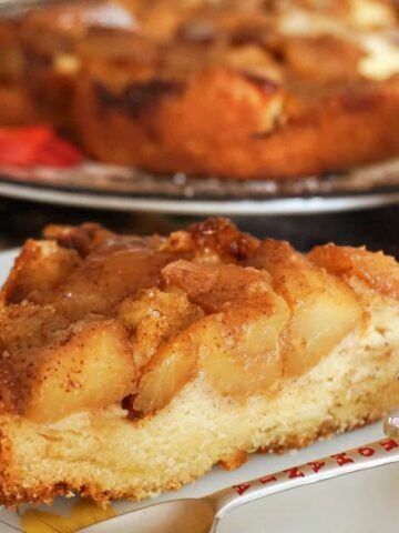 A slice of apple cake on a white plate