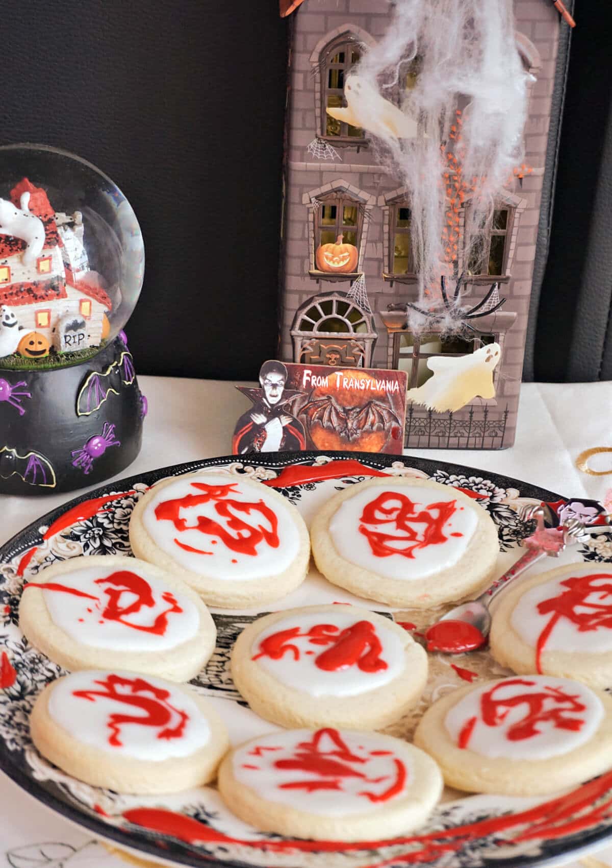 A plate with 8 halloween cookies and decorations around.