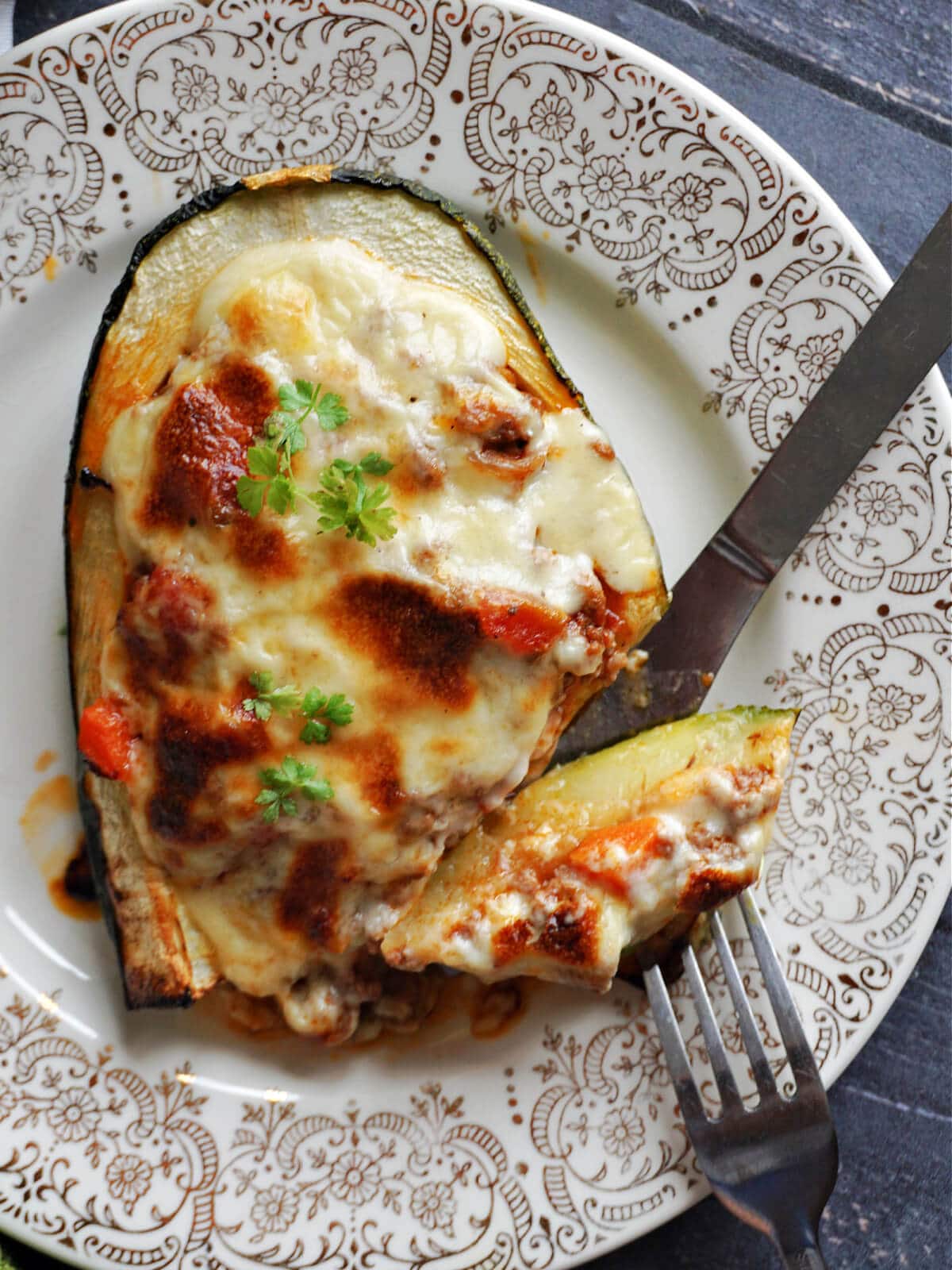 Overhead shoot of a quarter of a baked stuffed marrow.