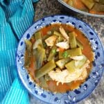 Overhead shoot of a blue bowl with green bean stew with shredded chicken