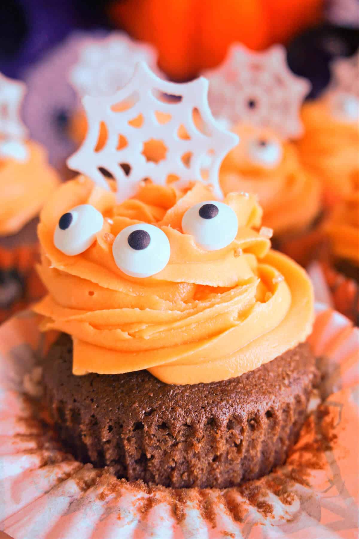 Close-up shoot of a cupcake with chocolate sponge and orange frosting
