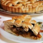 A slice of plum pie on a white plate