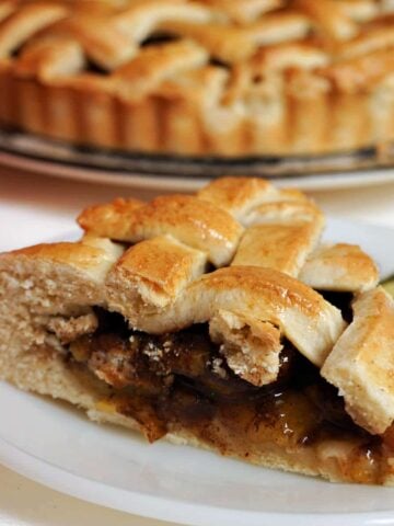 A slice of plum pie on a white plate