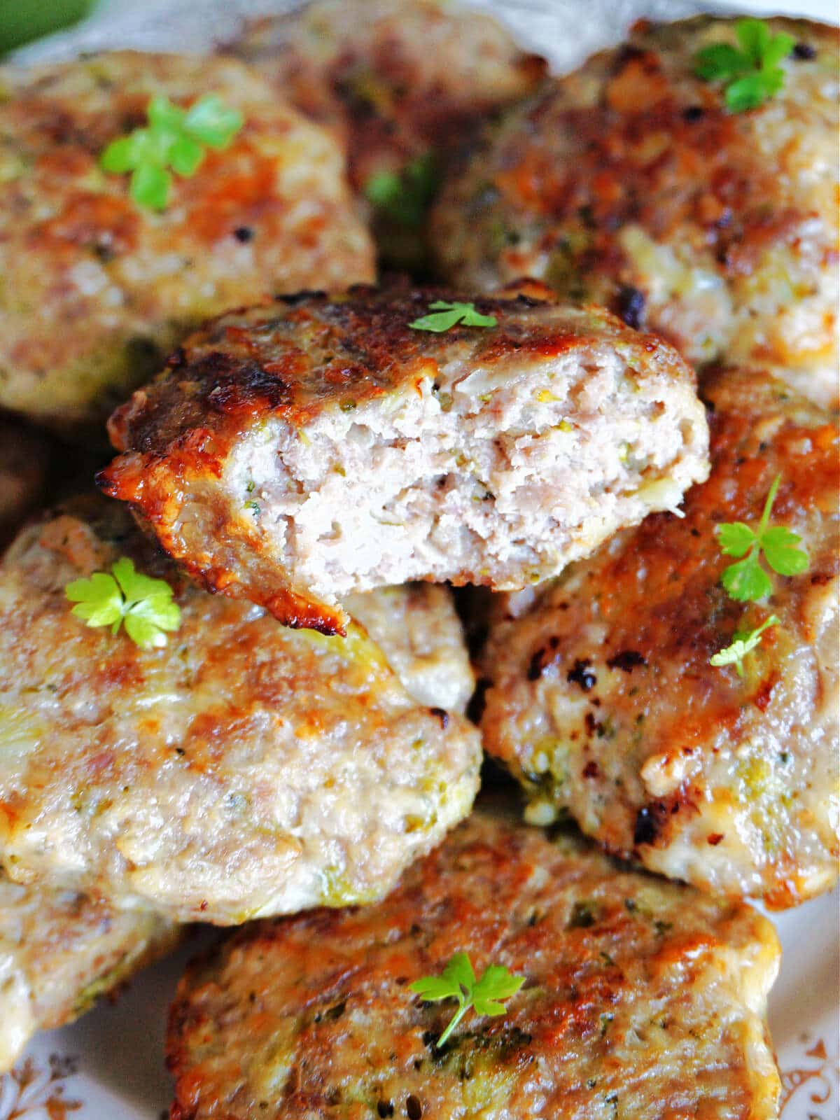 Close-up shoot of whole turkey patties with a half -eaten patty to show the inside.