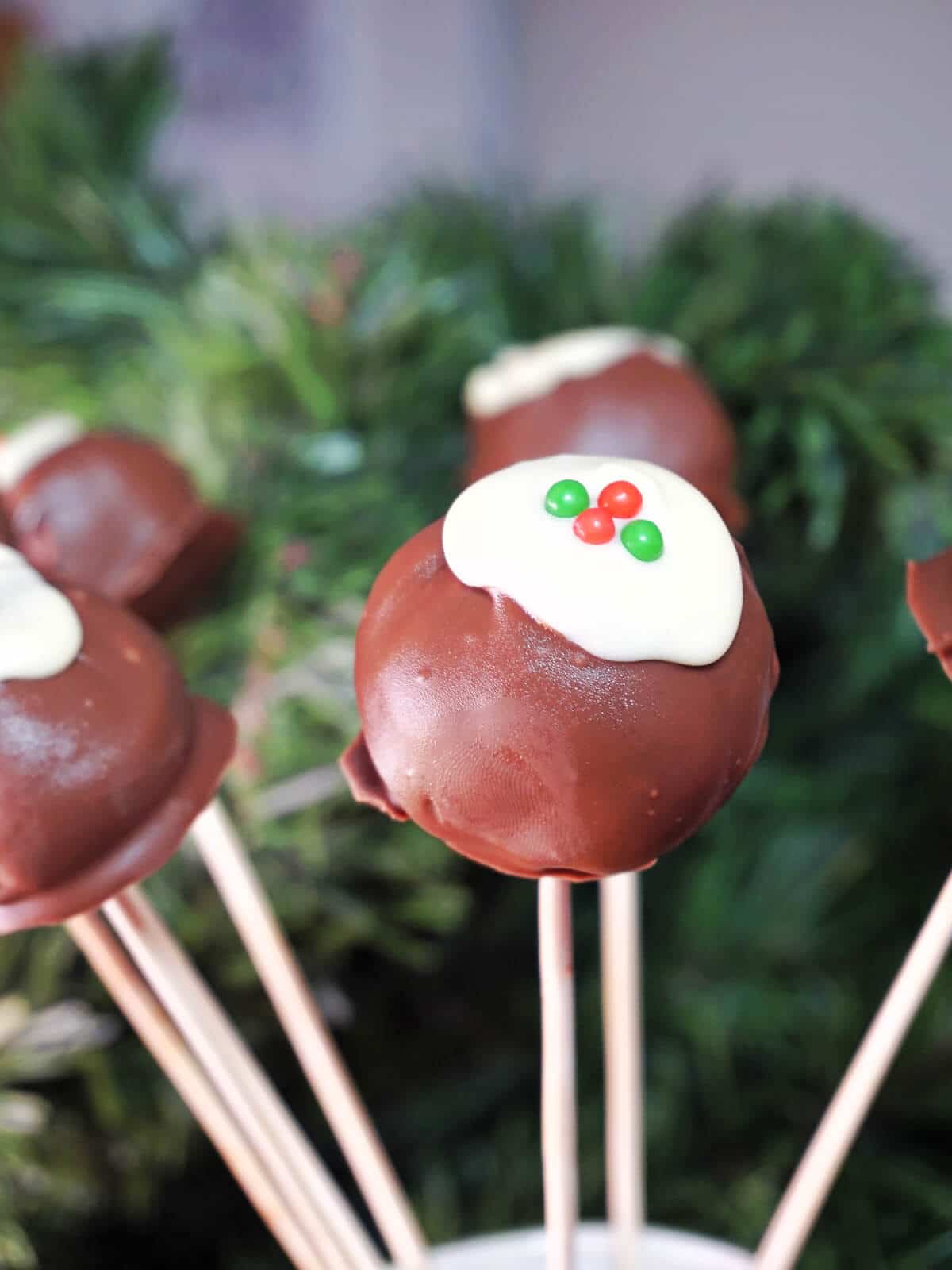 A jug with 6 Christmas pudding cake pops.