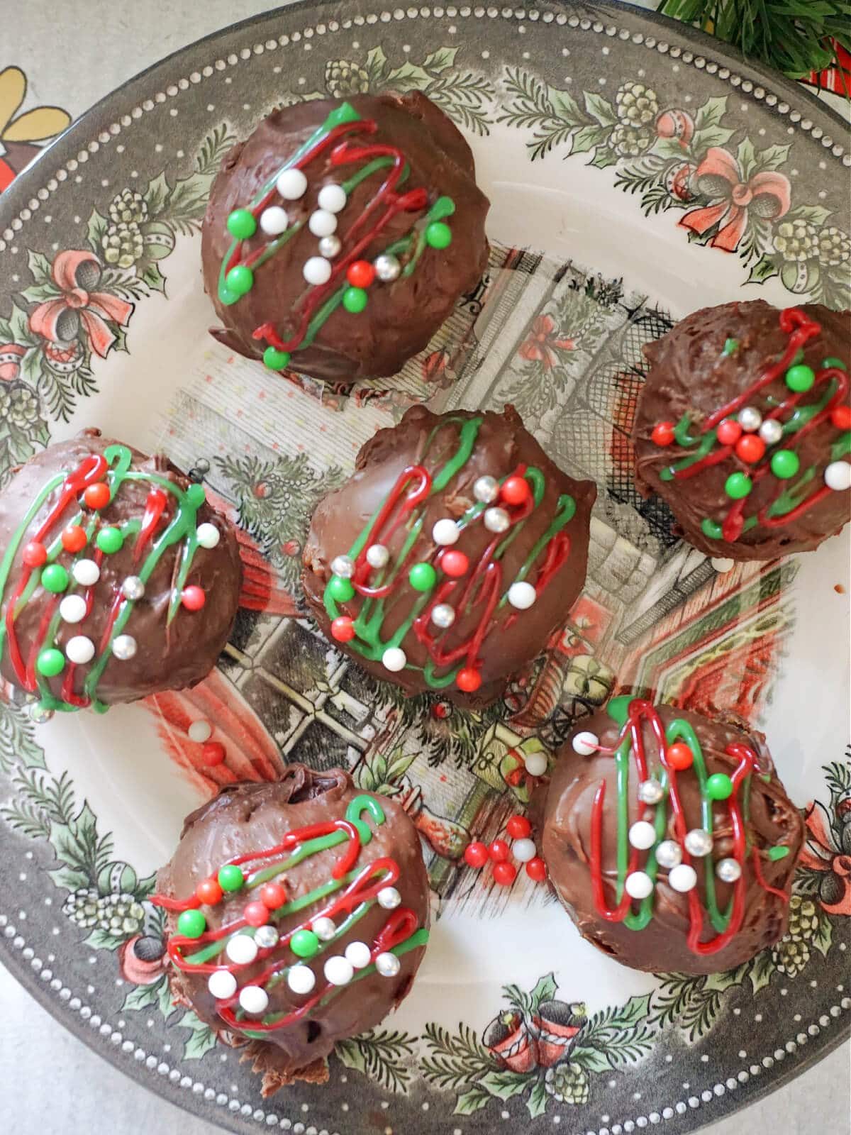 A plate with 6 chocolate-coated truffles.