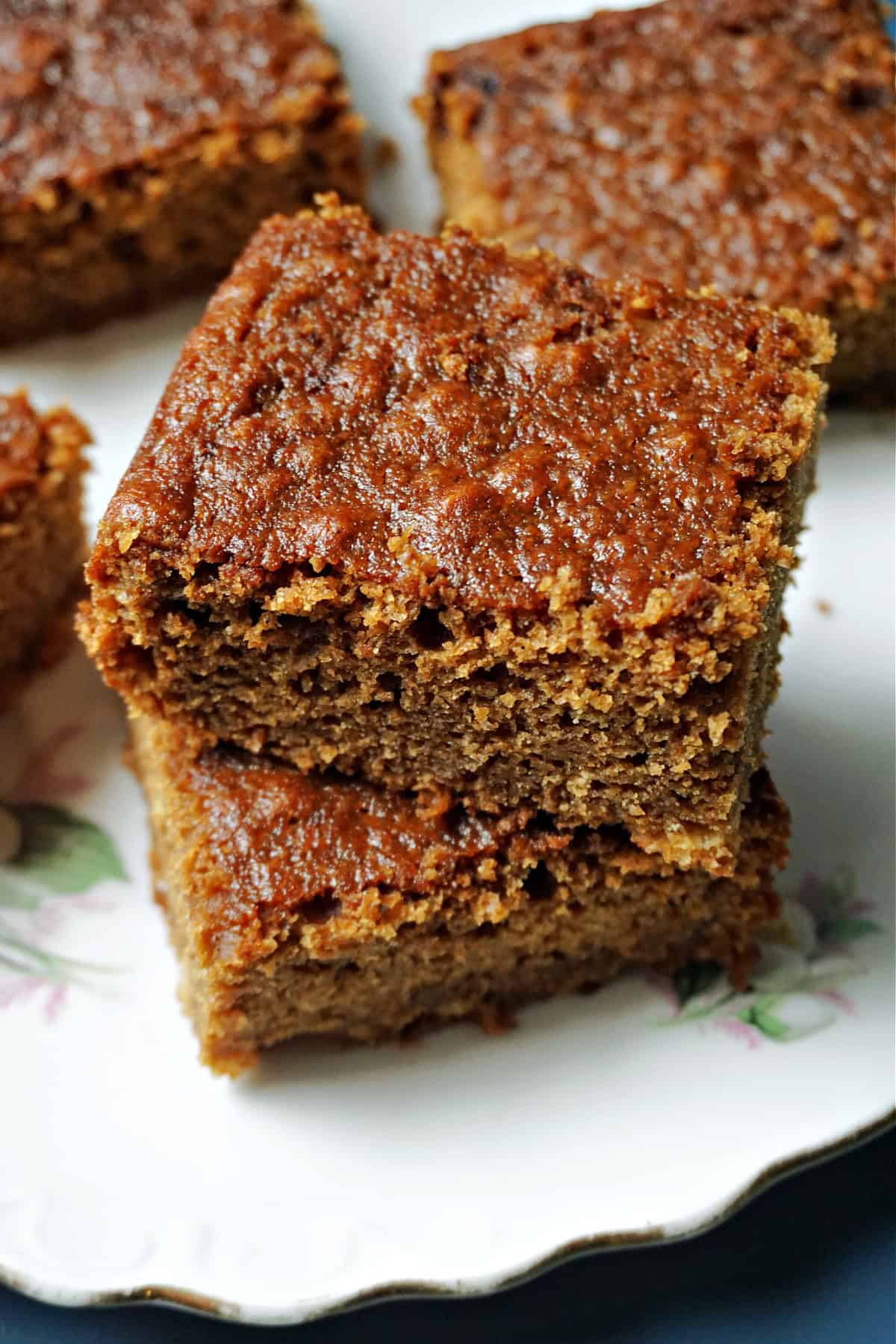 A stack of 2 slices of ginger cake on a white plate.
