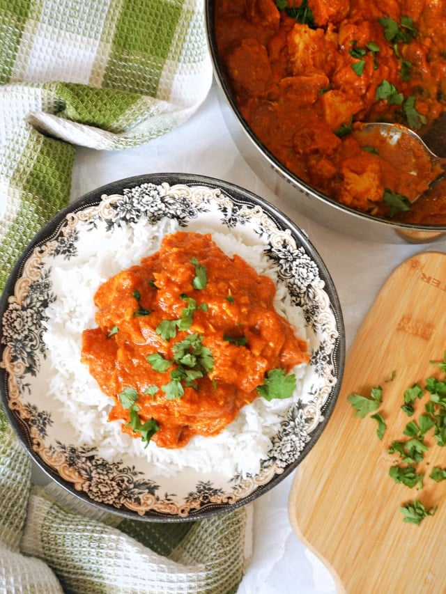 A plate with a portion of turkey curry.