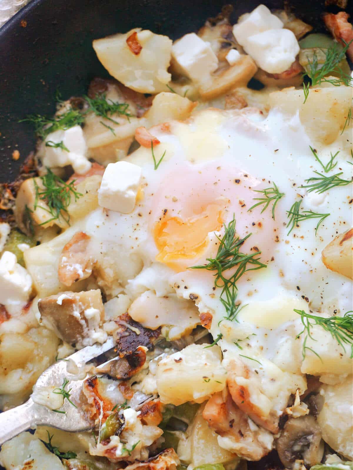 Close-up shoot of a pan with hash and eggs.