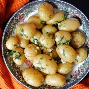 A bowl with baby potatoes with herbs and garlic