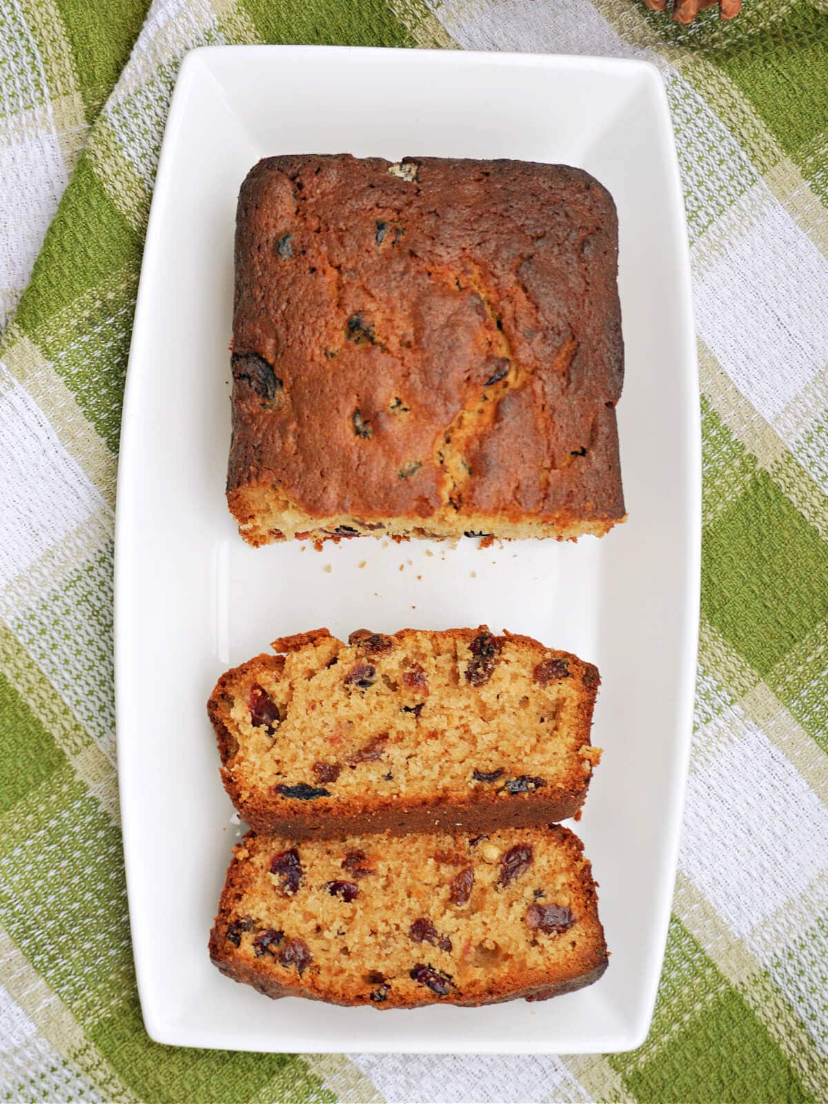 A rectangle white plate with a sliced loaf cake.