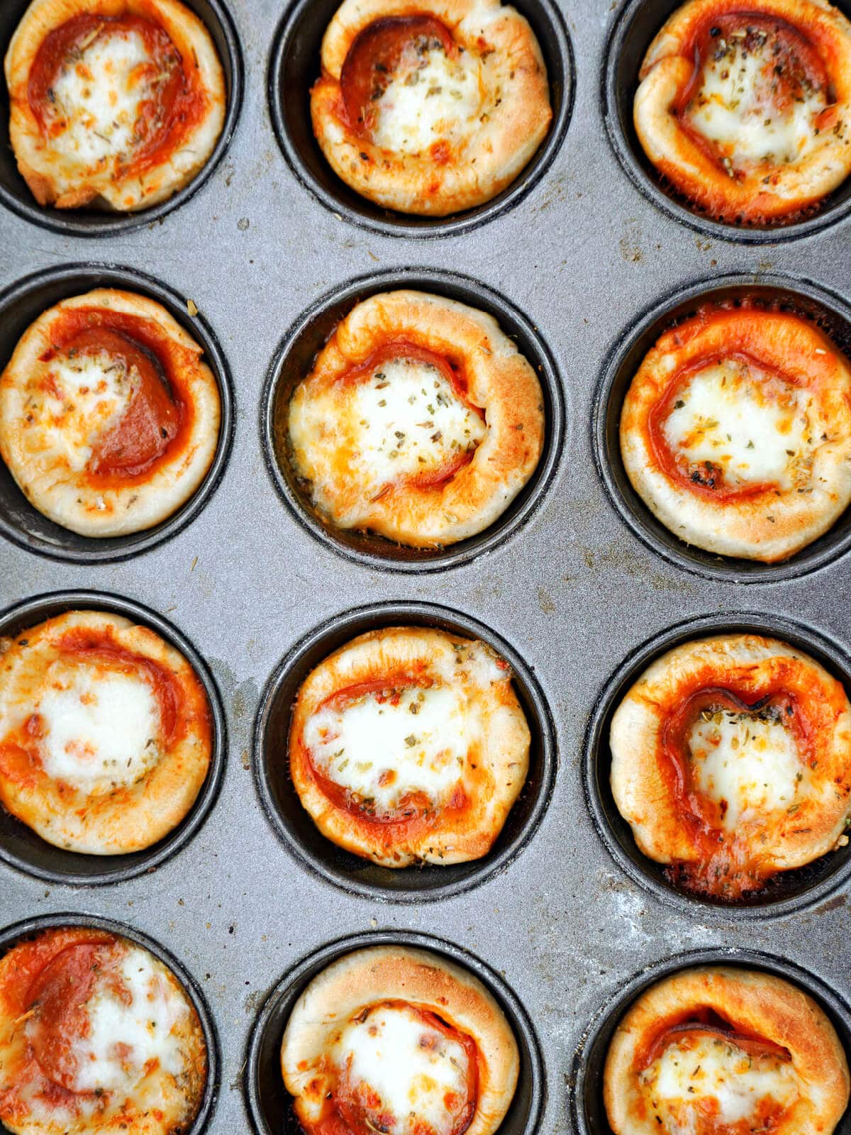 Overhead shoot of a muffin tin with mini pizzas