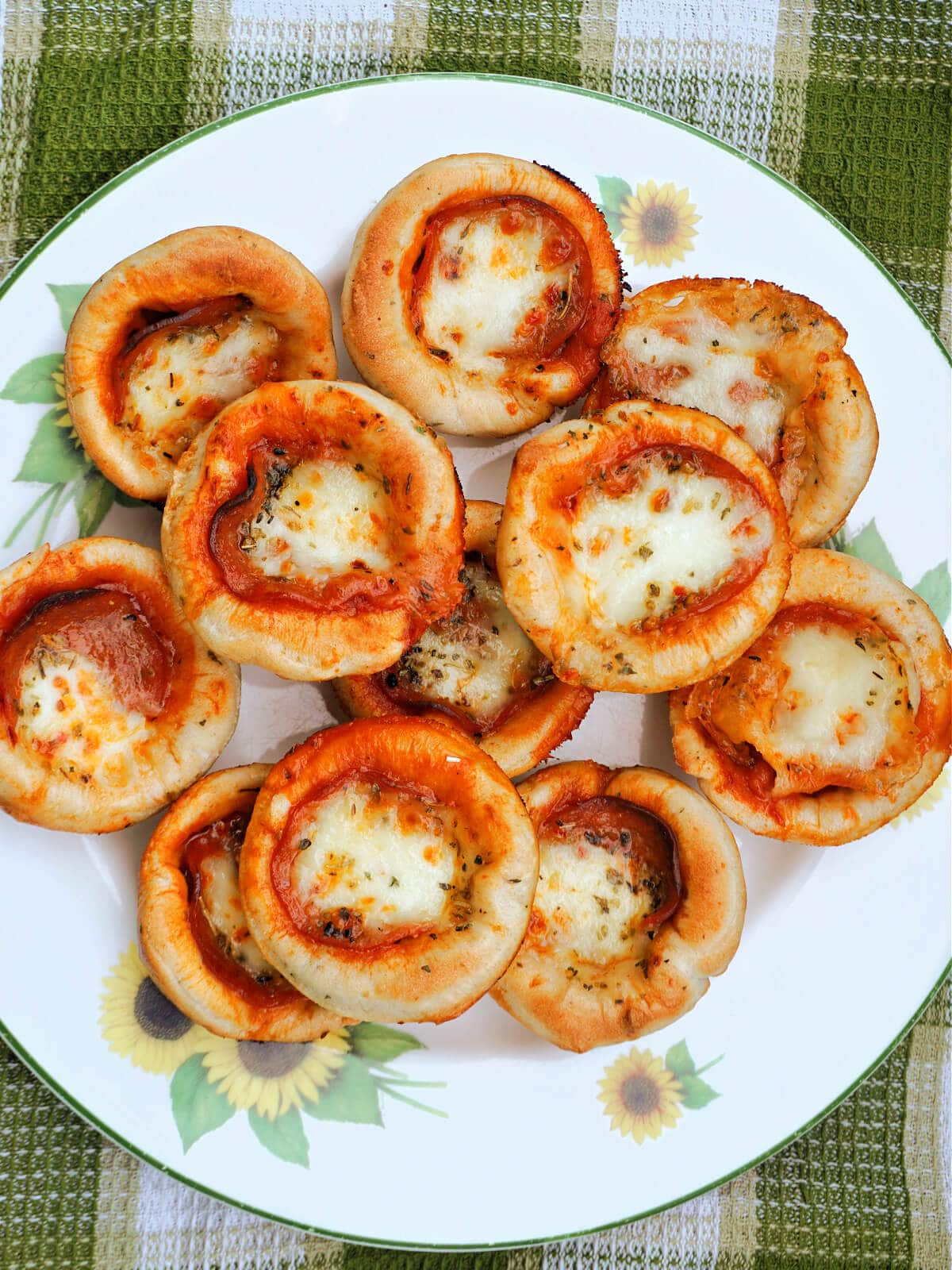 A plate with mini pepperoni pizzas.