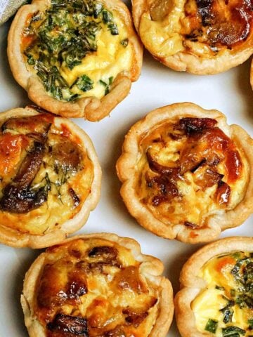 Close-up shoot of 8 mini quiches on a white plate