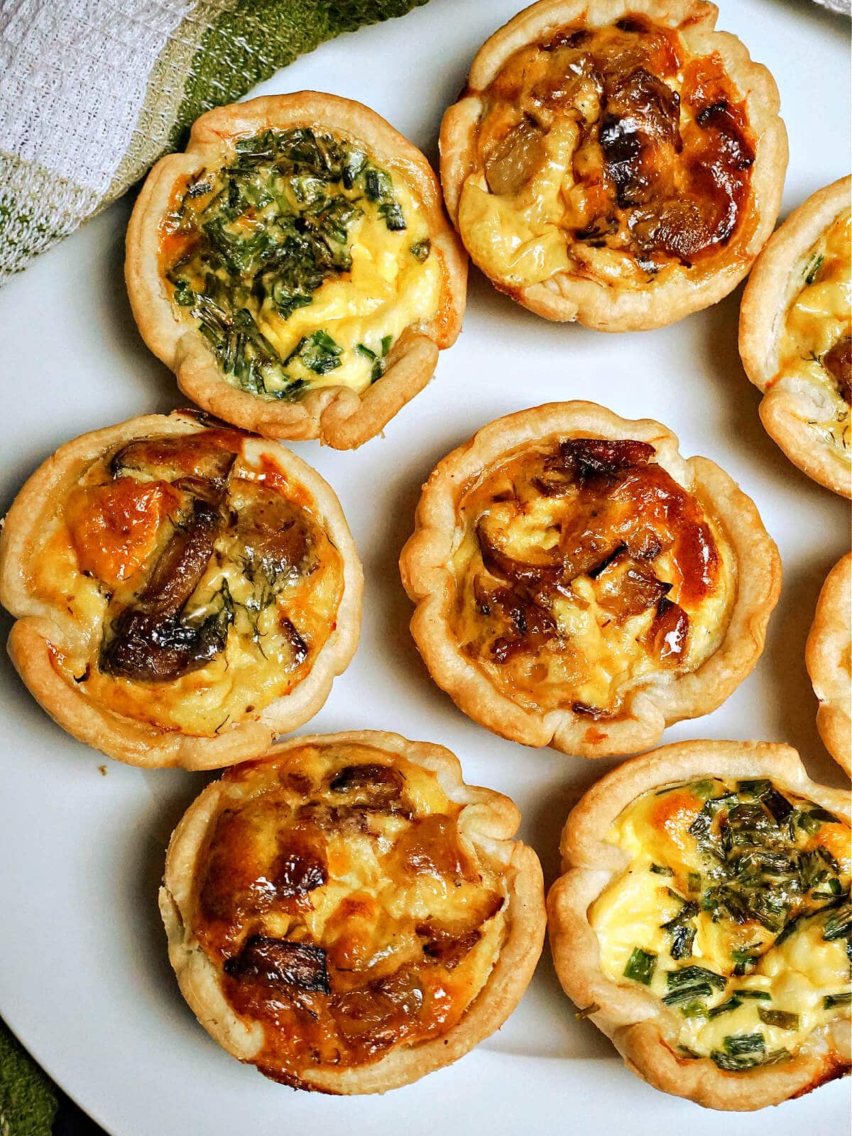 A white plate with mini quiches.