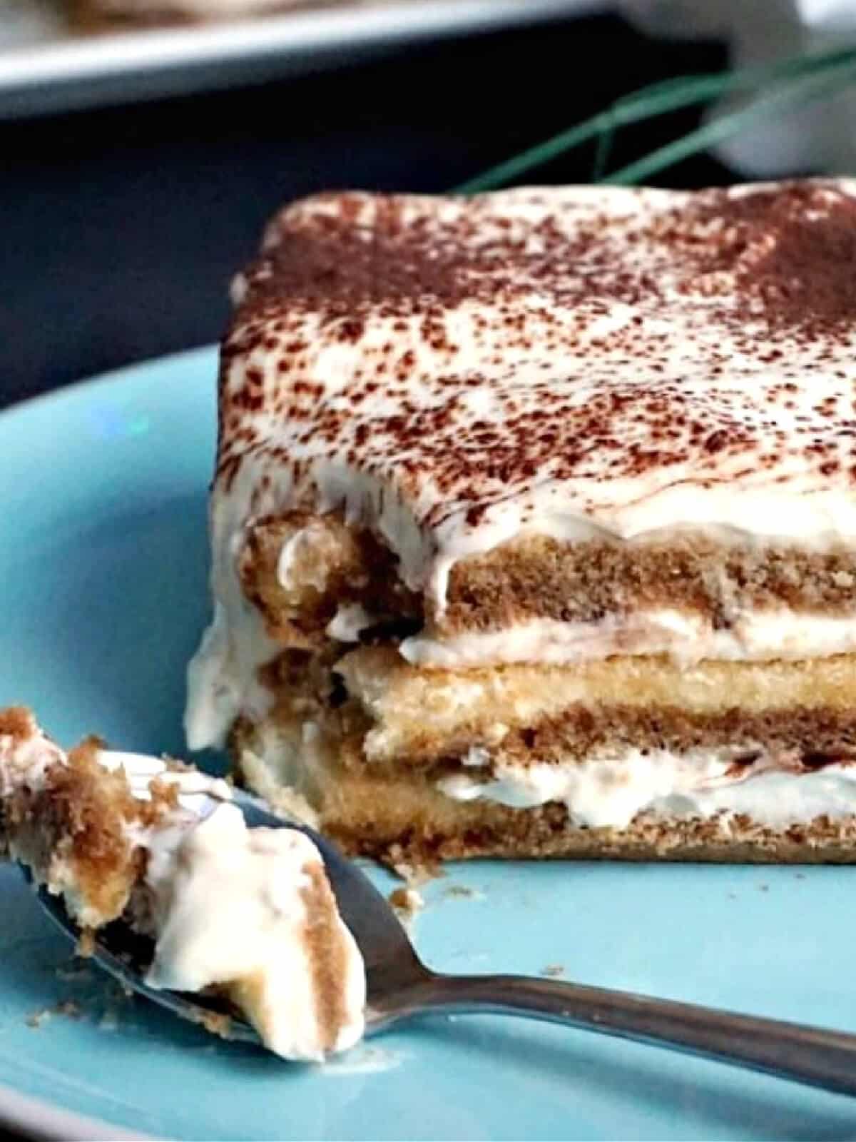 A slice of tiramisu on a blue plate.