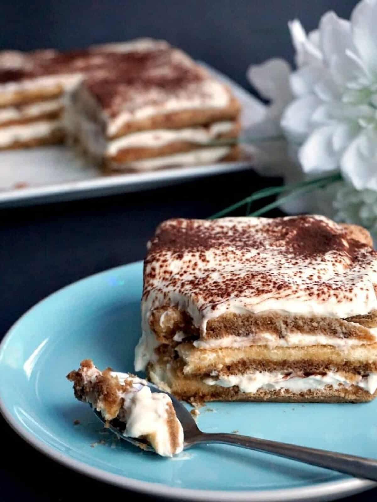 A slice of tiramisu on a light blue plate