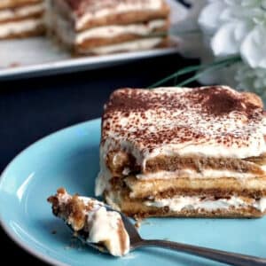 A slice of tiramisu on a light blue plate