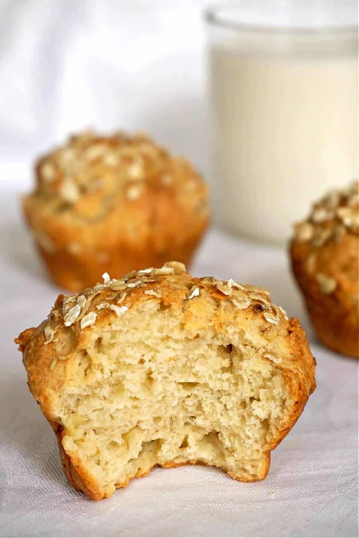 Half of a muffin with 2 more muffins in the background