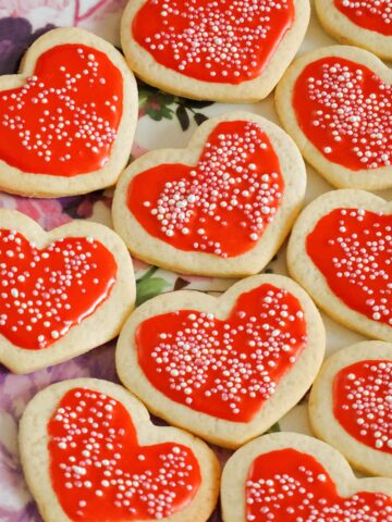 red heart-shaped cookies with sprinkles on top