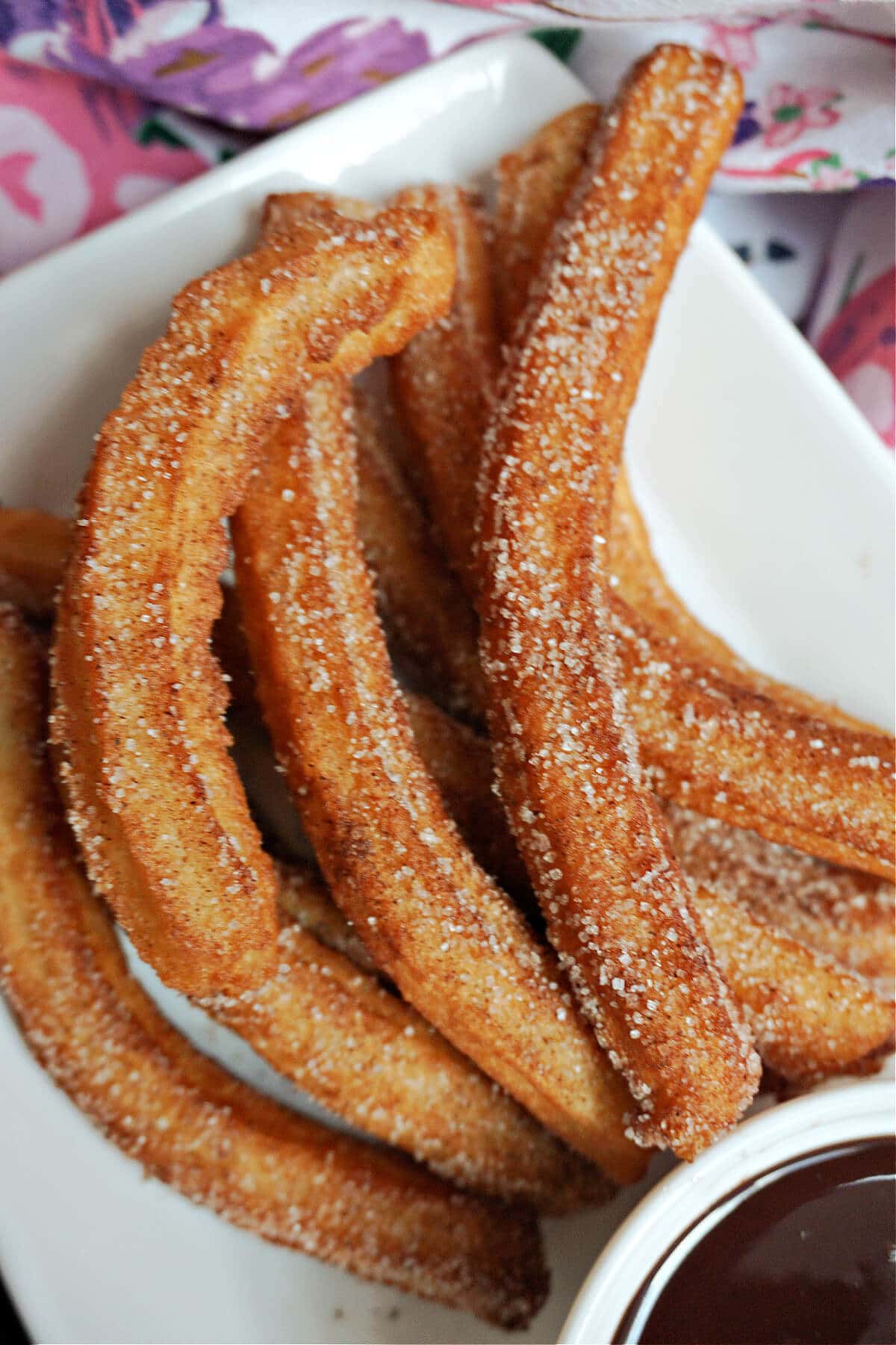 Close-up shoot of churros on a white plate.