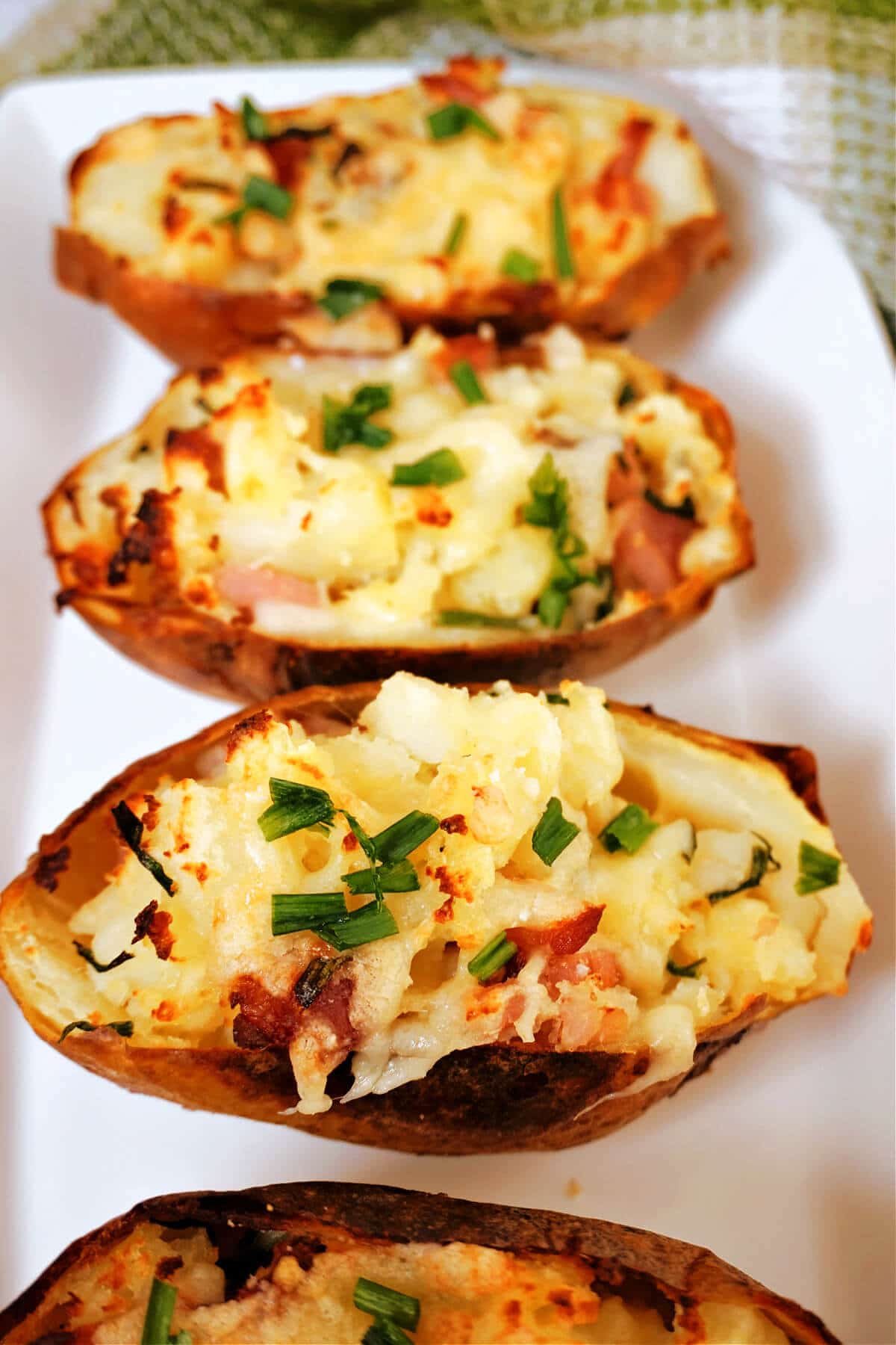 4 baked potato skins on a white plate.