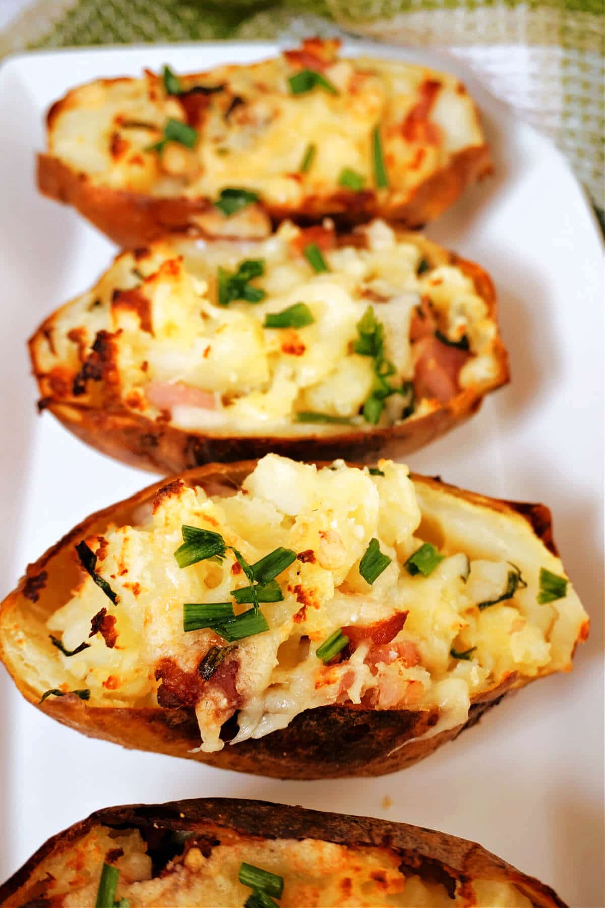 4 baked potato skins on a white plate.