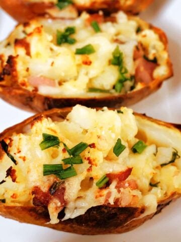 2 loaded potato skins on a white plate