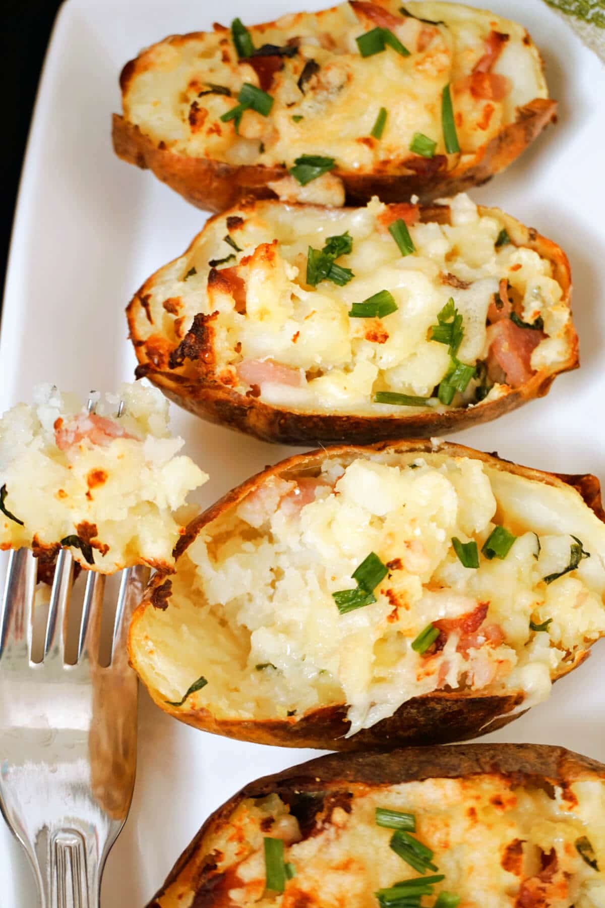 Overhead shoot of a white rectangle plate with 4 potato skins.