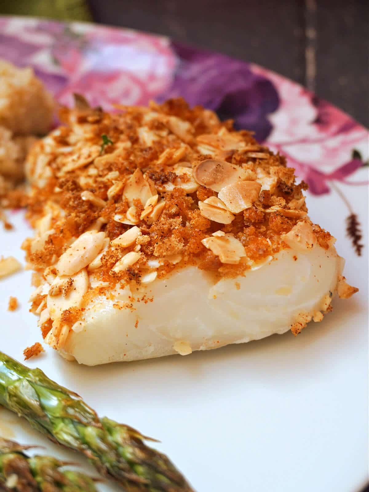 A crusted cod fillet on a white plate.