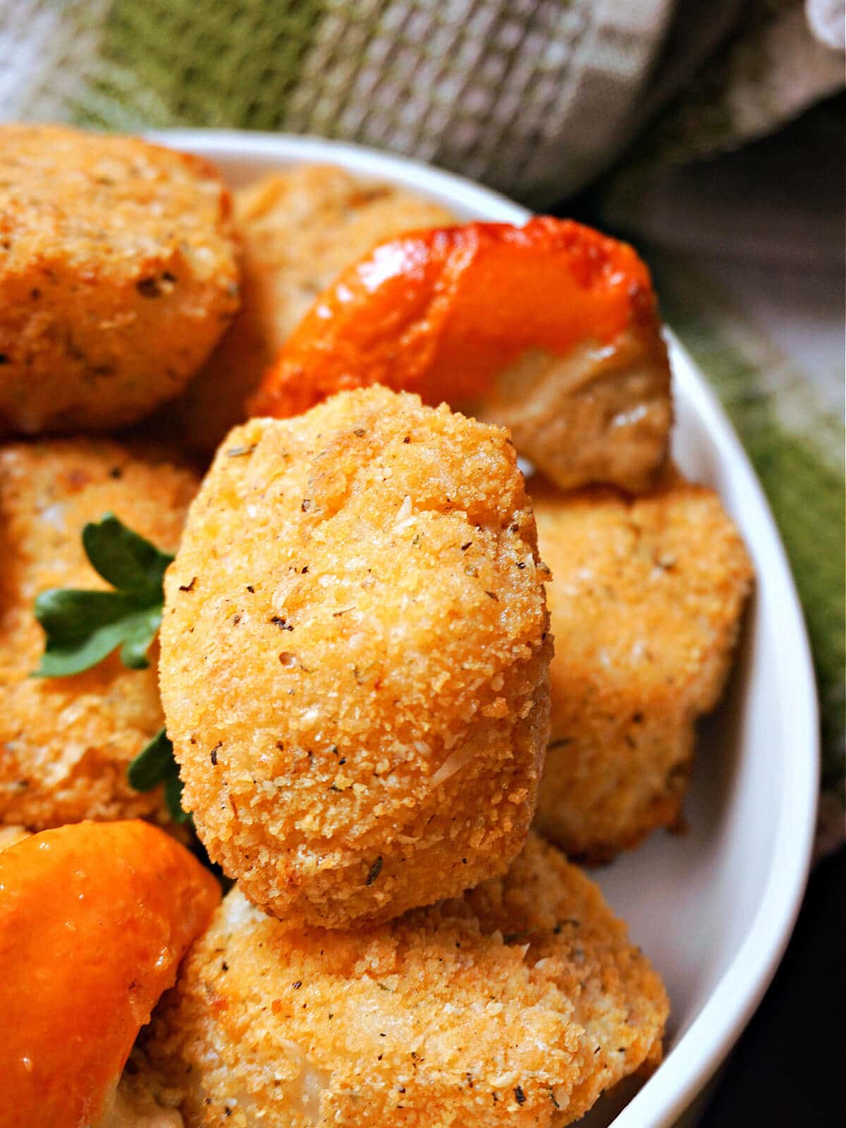 A white bowl with breaded scallops.