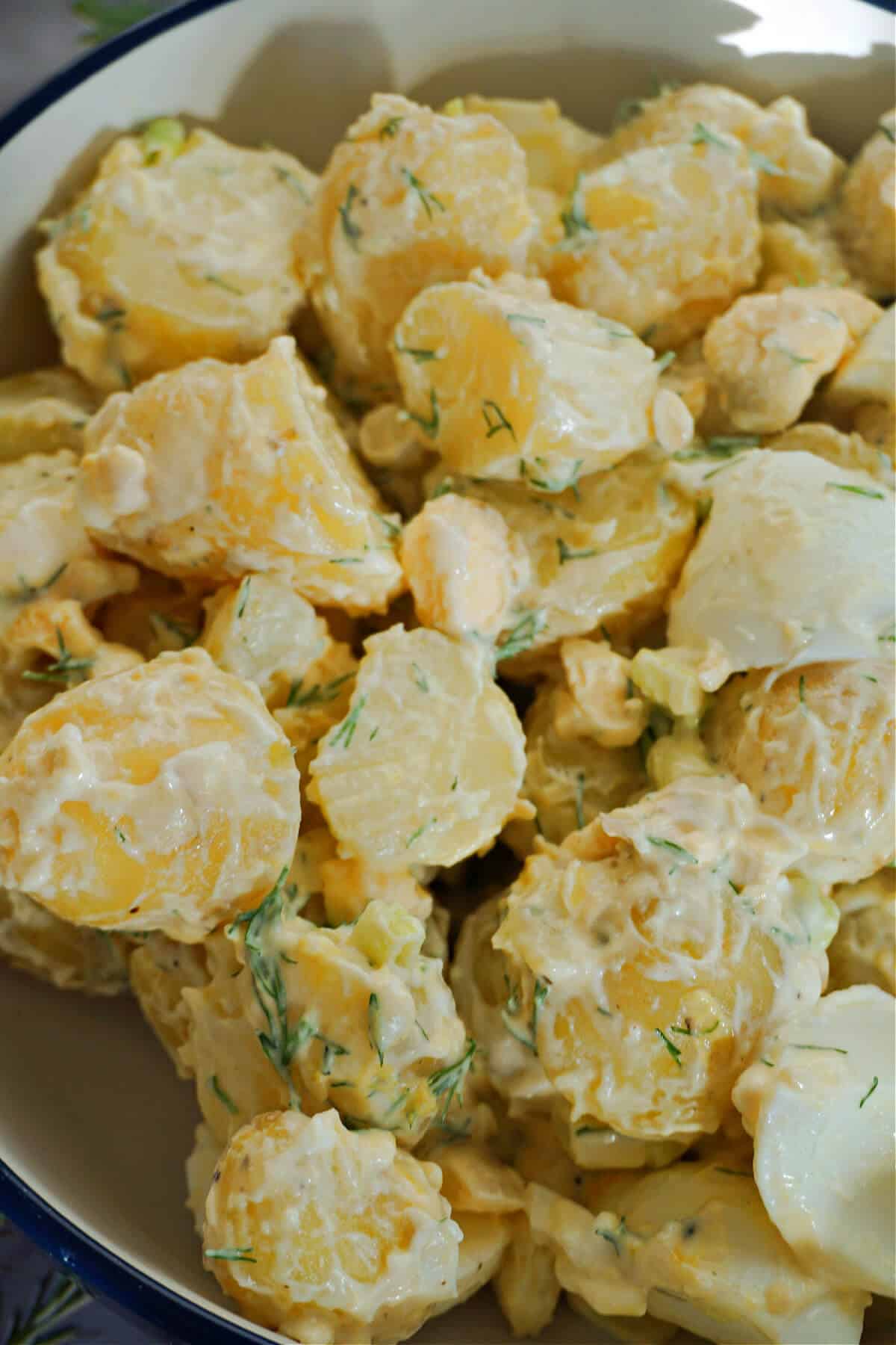 Close-up shoot of potato salad in a white bowl.