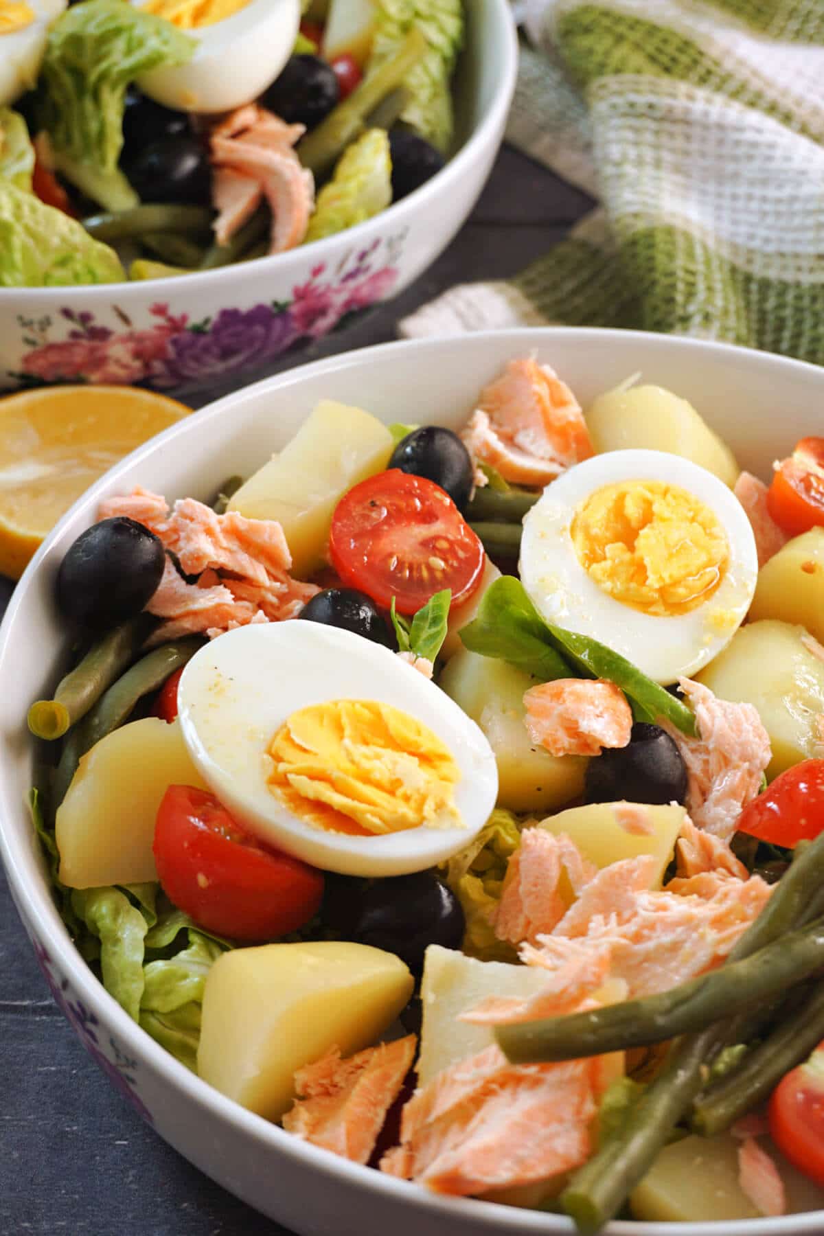 A white bowl of salmon nicoise salad.