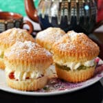 4 mini Victoria Sponge Cakes on a plate with a tea pot in the background