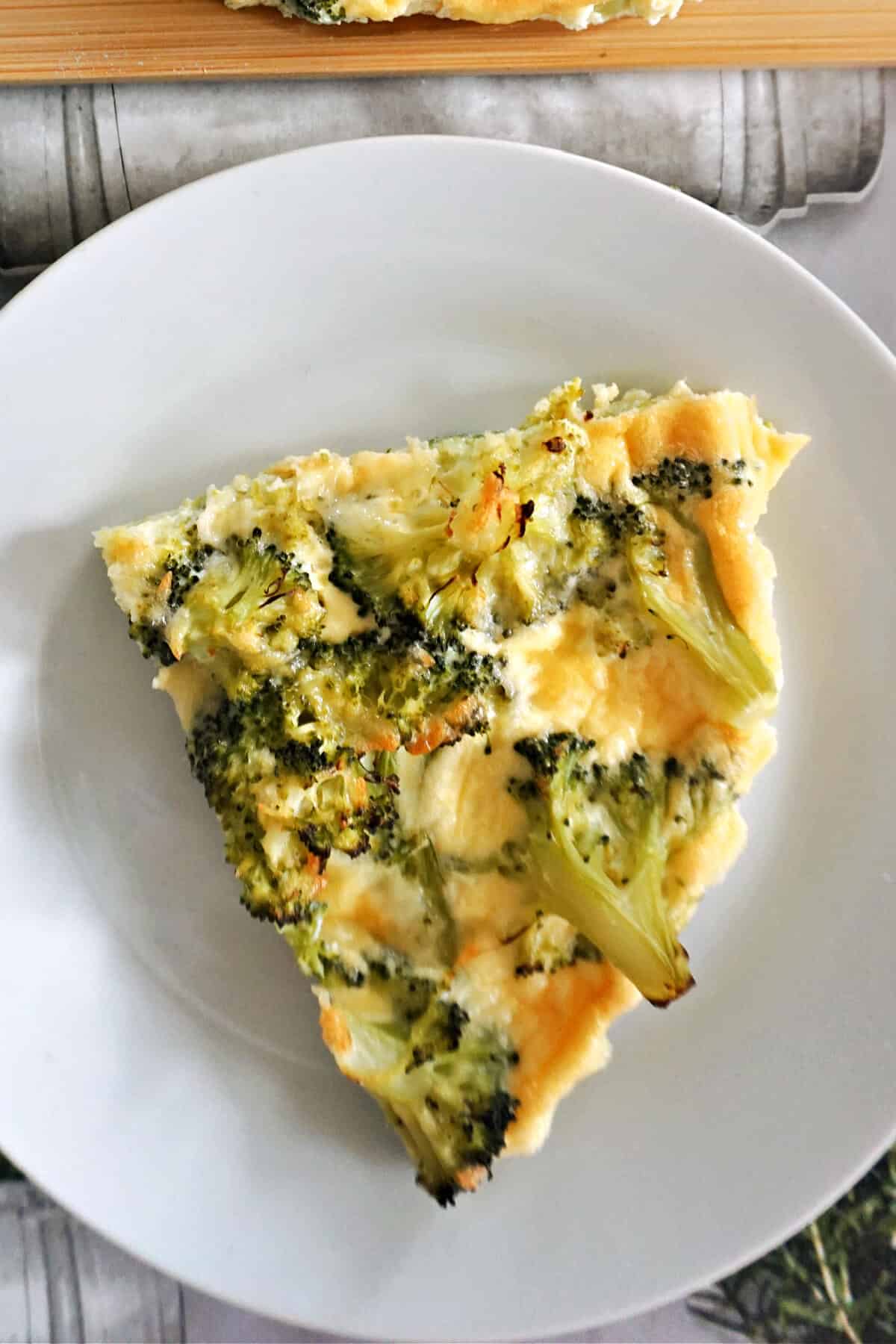 A slice of crustless quiche on a white plate.