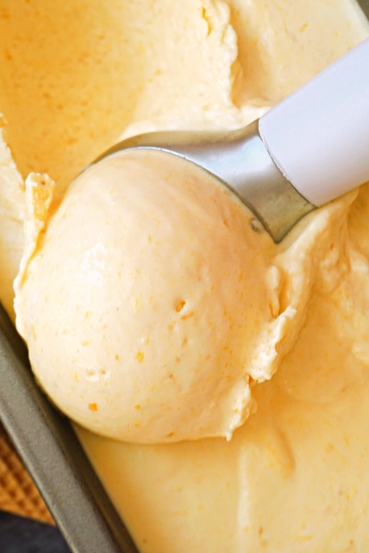 Close-up shoot of a scoop of mango ice cream .