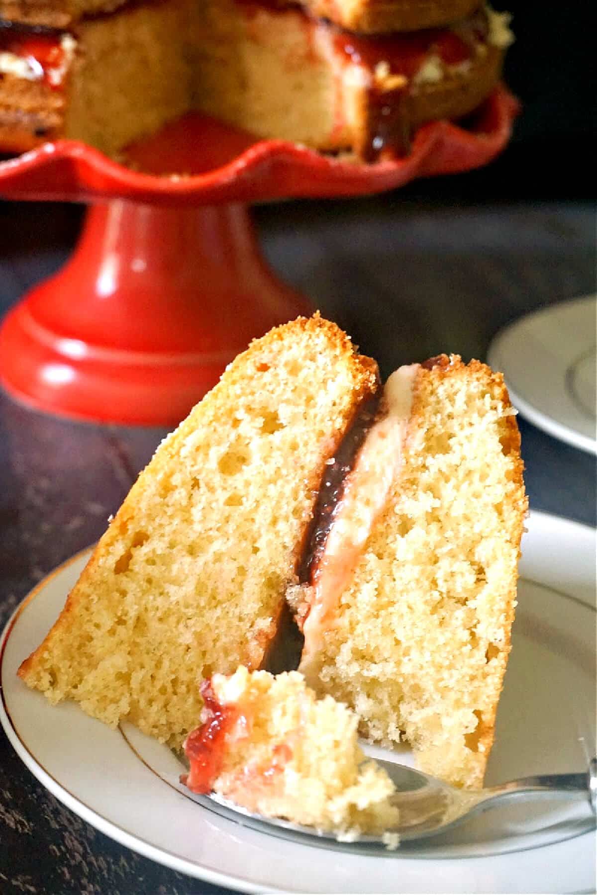 A slice of Victoria sponge on a white plate.