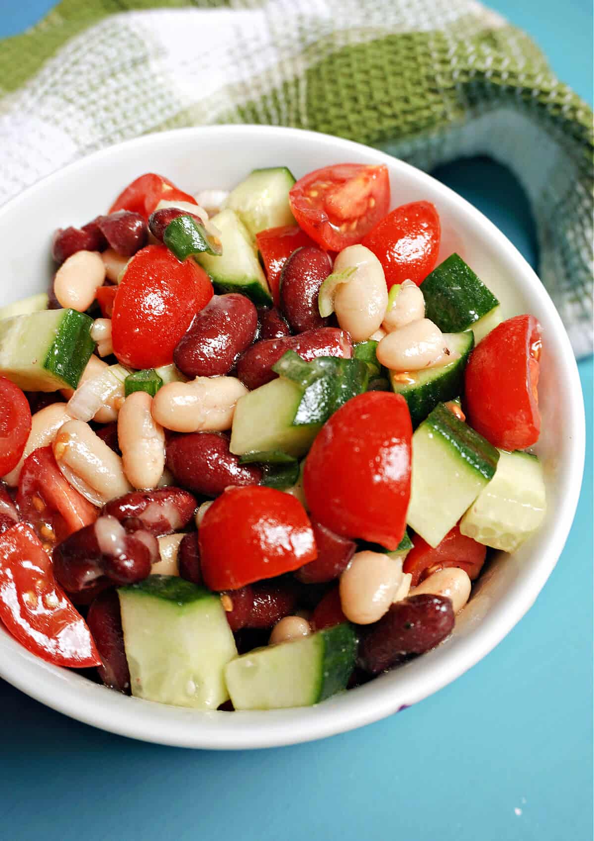 A white bowl with bean and veggie salad.