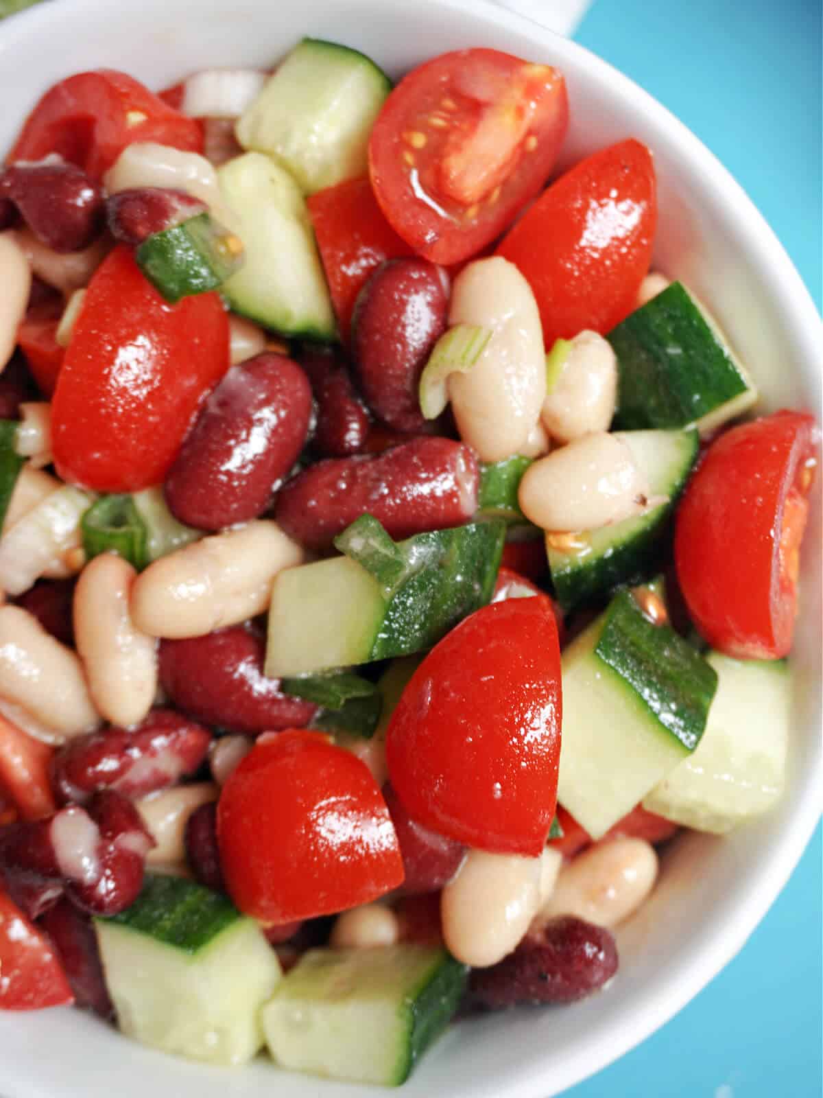Close-up shoot of a white bowl with bean salad.