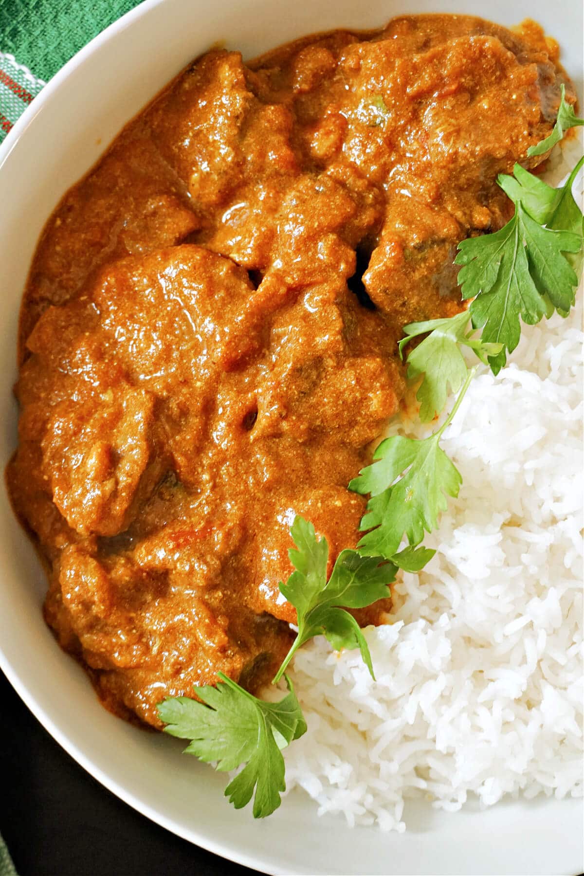 A white bowl with rice and beef curry.