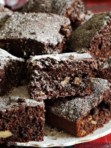 A white plate with squares of cakey brownies.