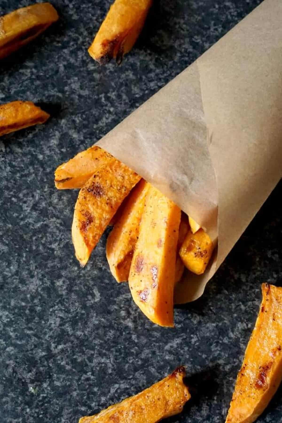 a paper cone with sweet potato fries.
