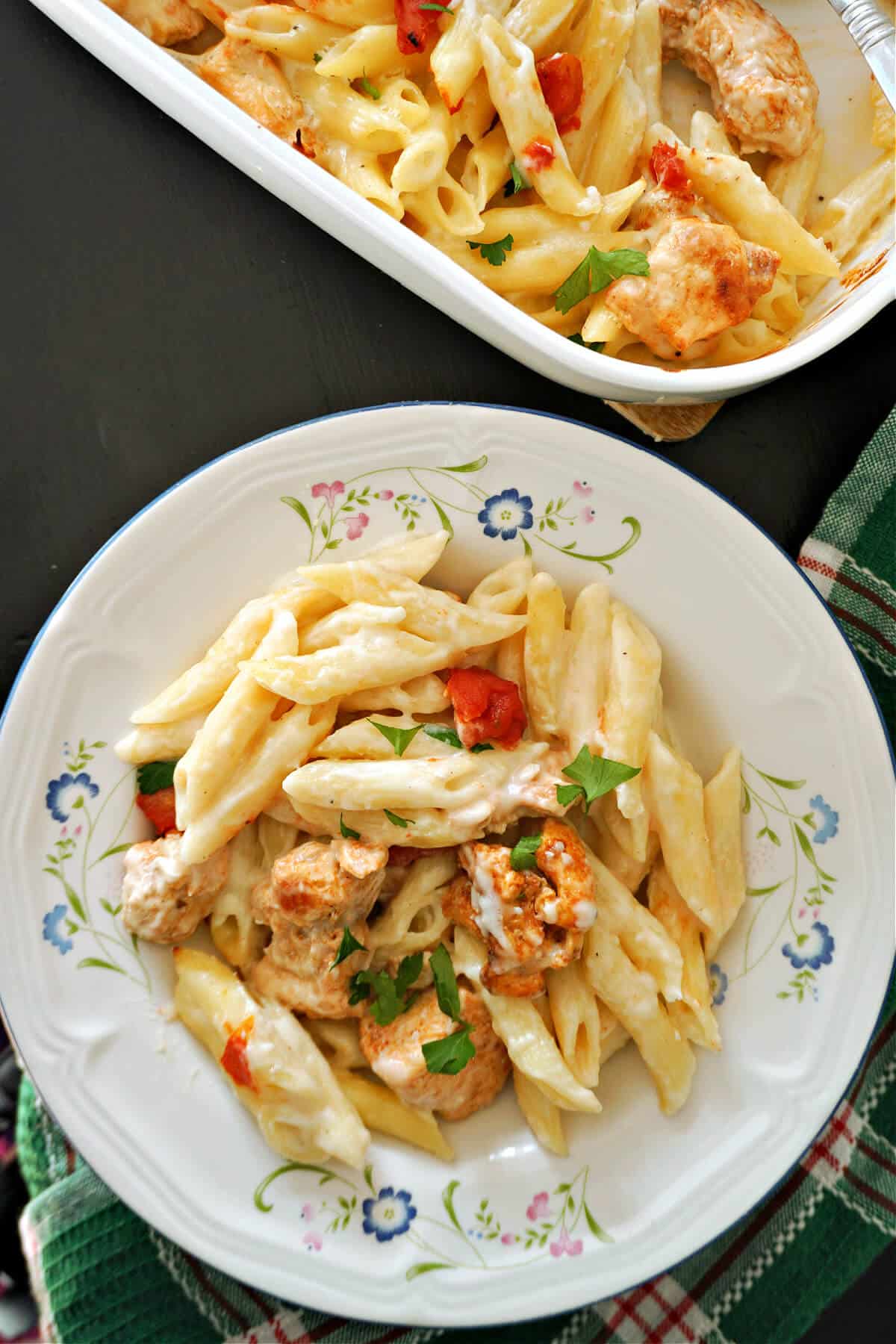A white plate with chicken pasta.