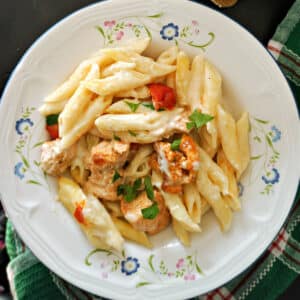 A white plate with creamy chicken pasta bake.