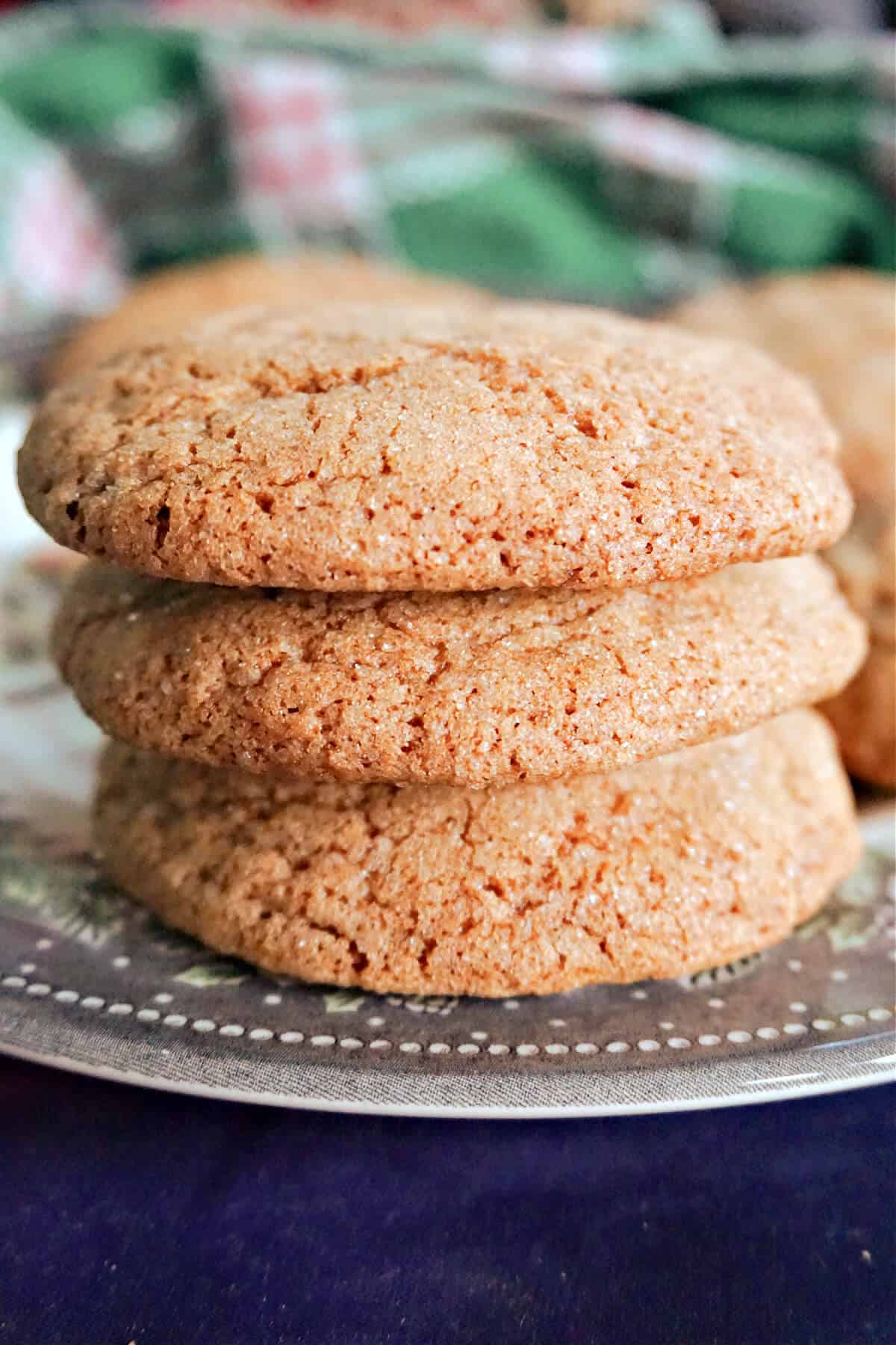 A pile of 3 ginger cookies on a plate.