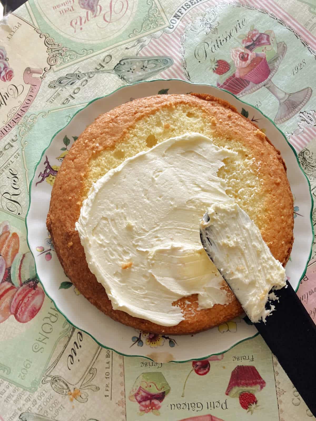 A sponge cake being decorated with buttercream.