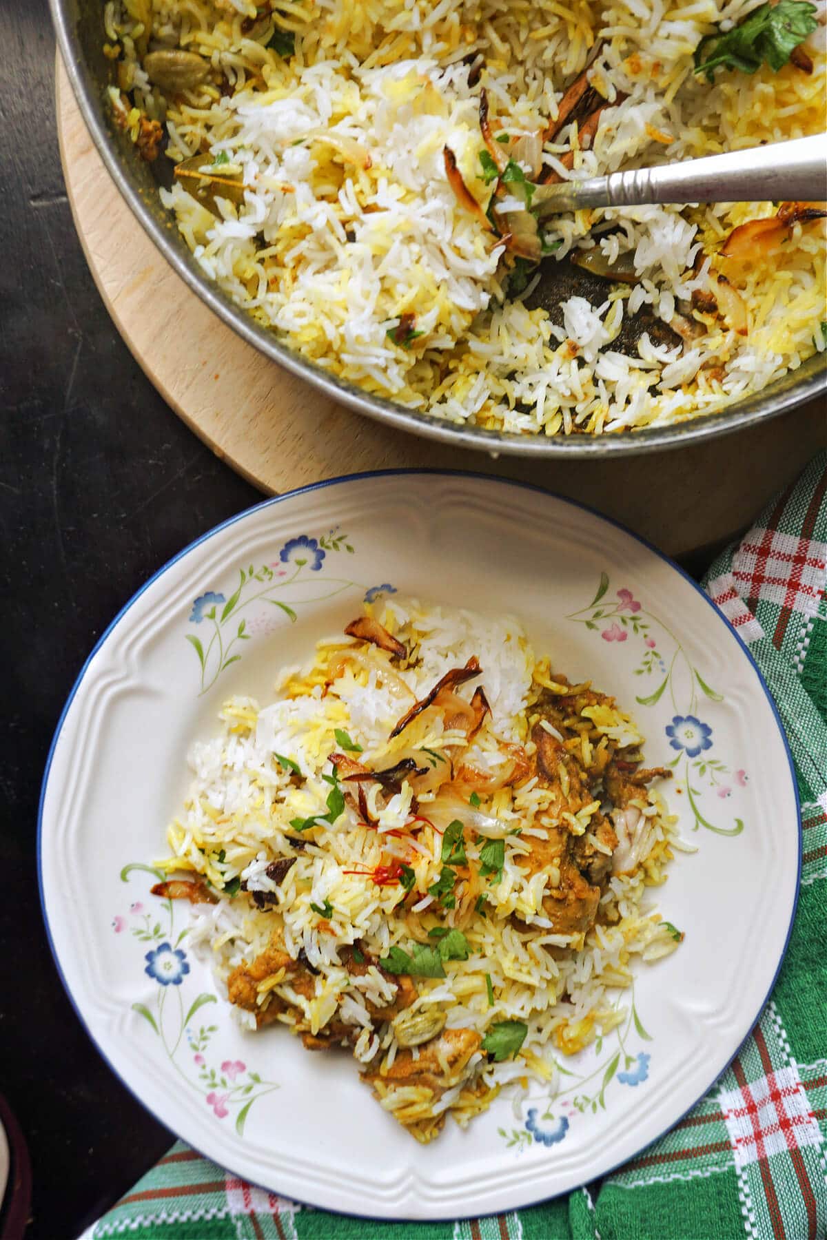 A plate with biryani and a pan with more of the dish.