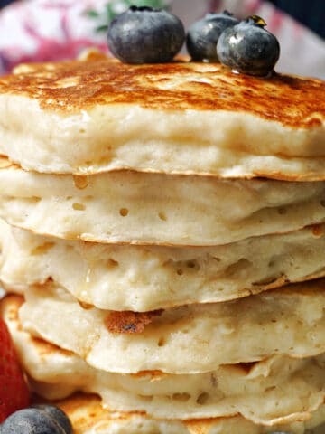 A pile of pancakes with blueberries on top